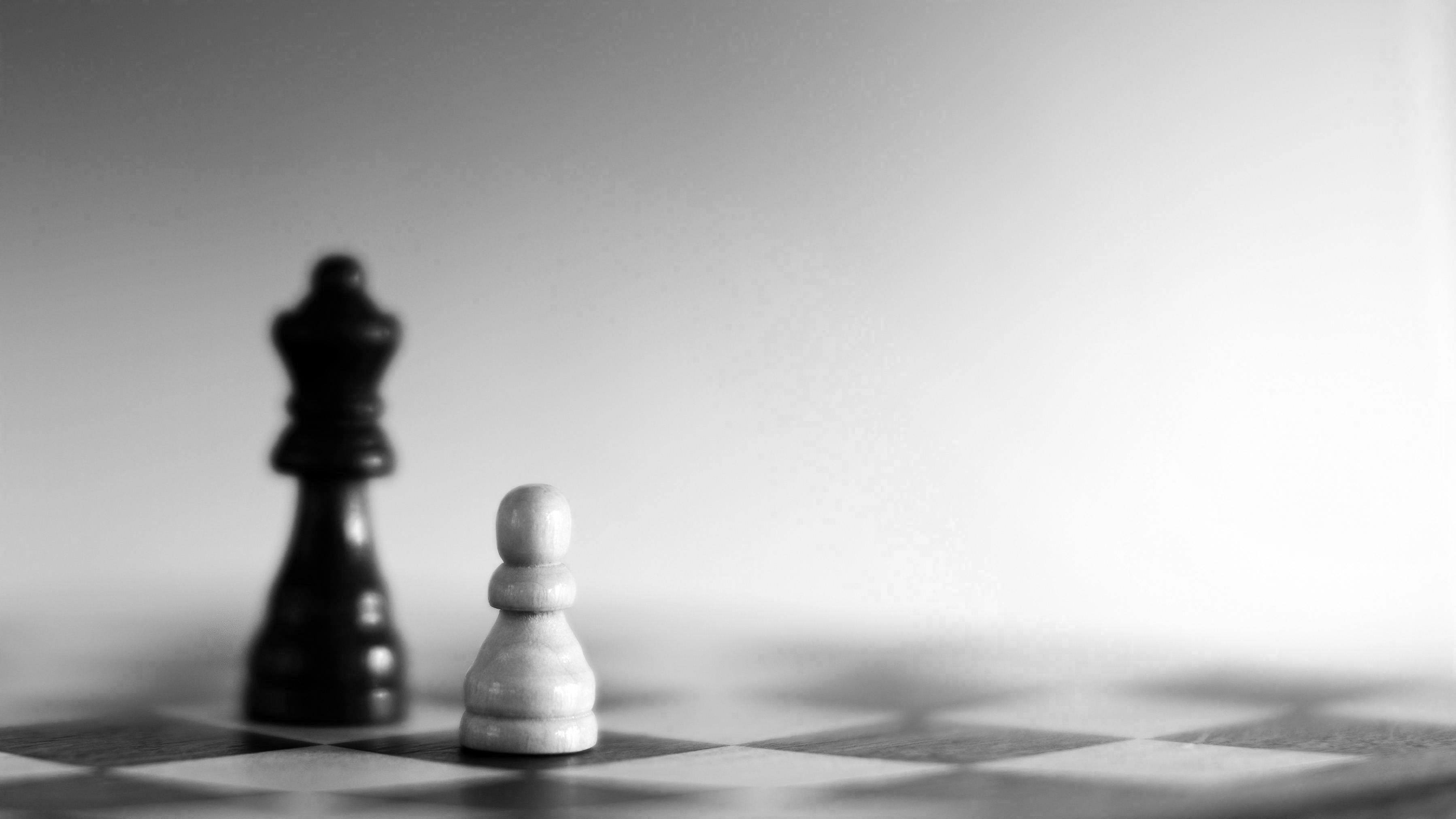 Grayscale photography of two chess pieces on a chessboard